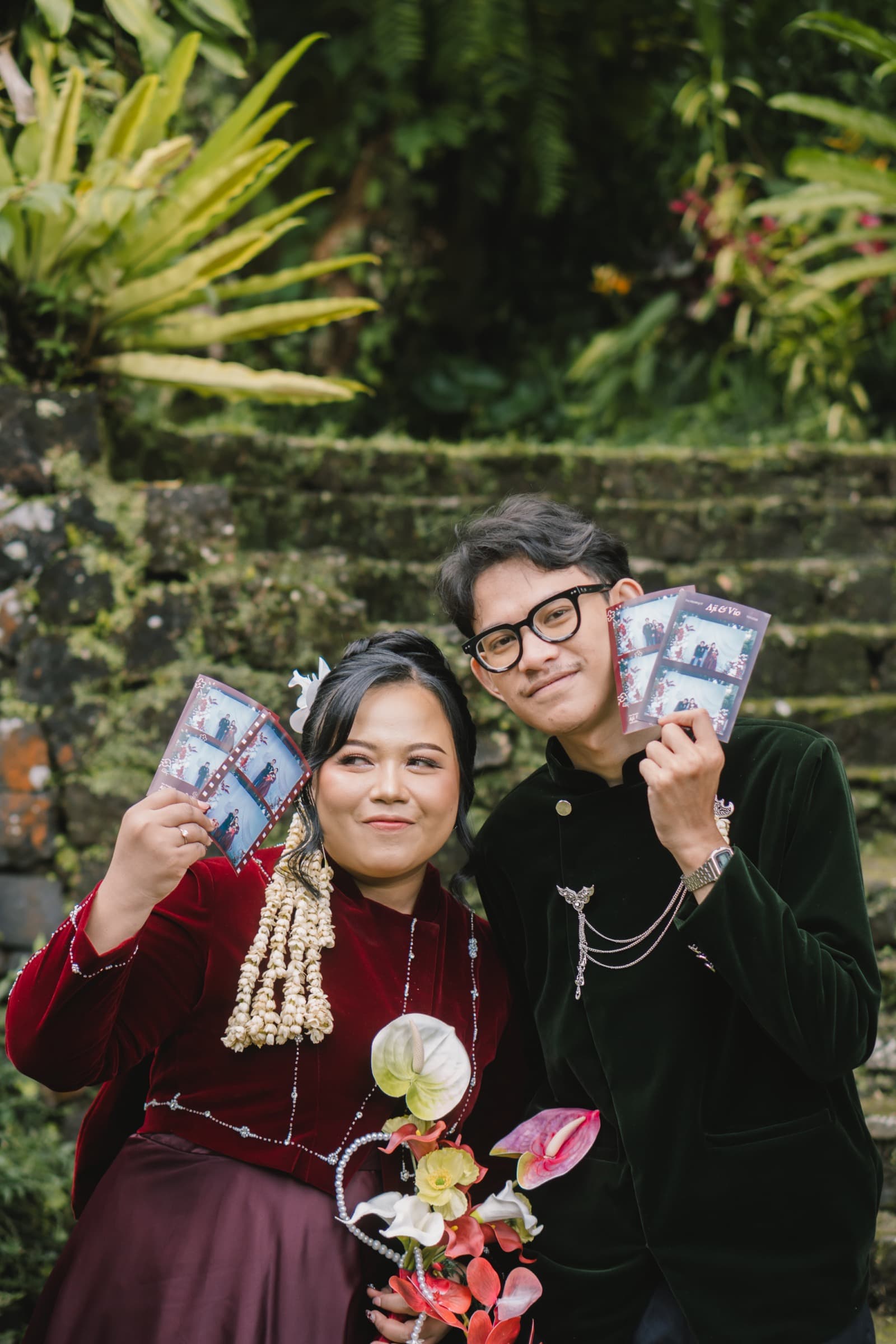 Pasangan pengantin memegang hasil cetak photostrip Pictosnap